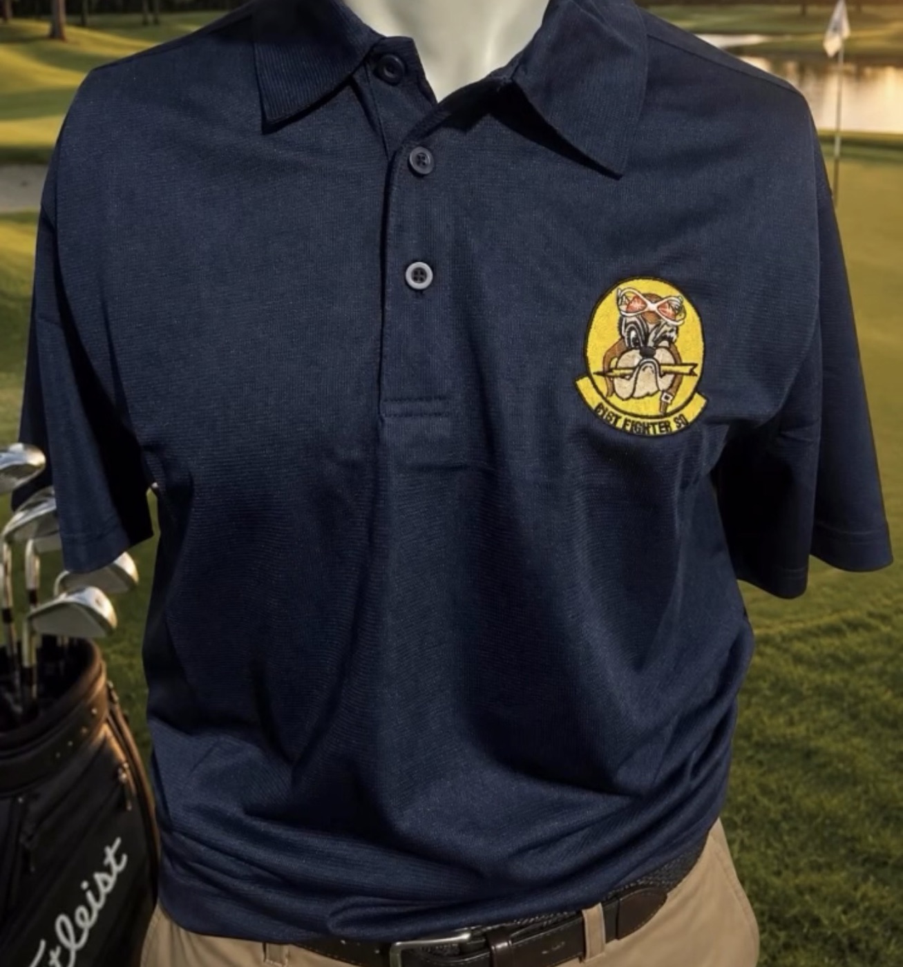 Woven 61st Fighter Squadron patch appliqued on a navy polo