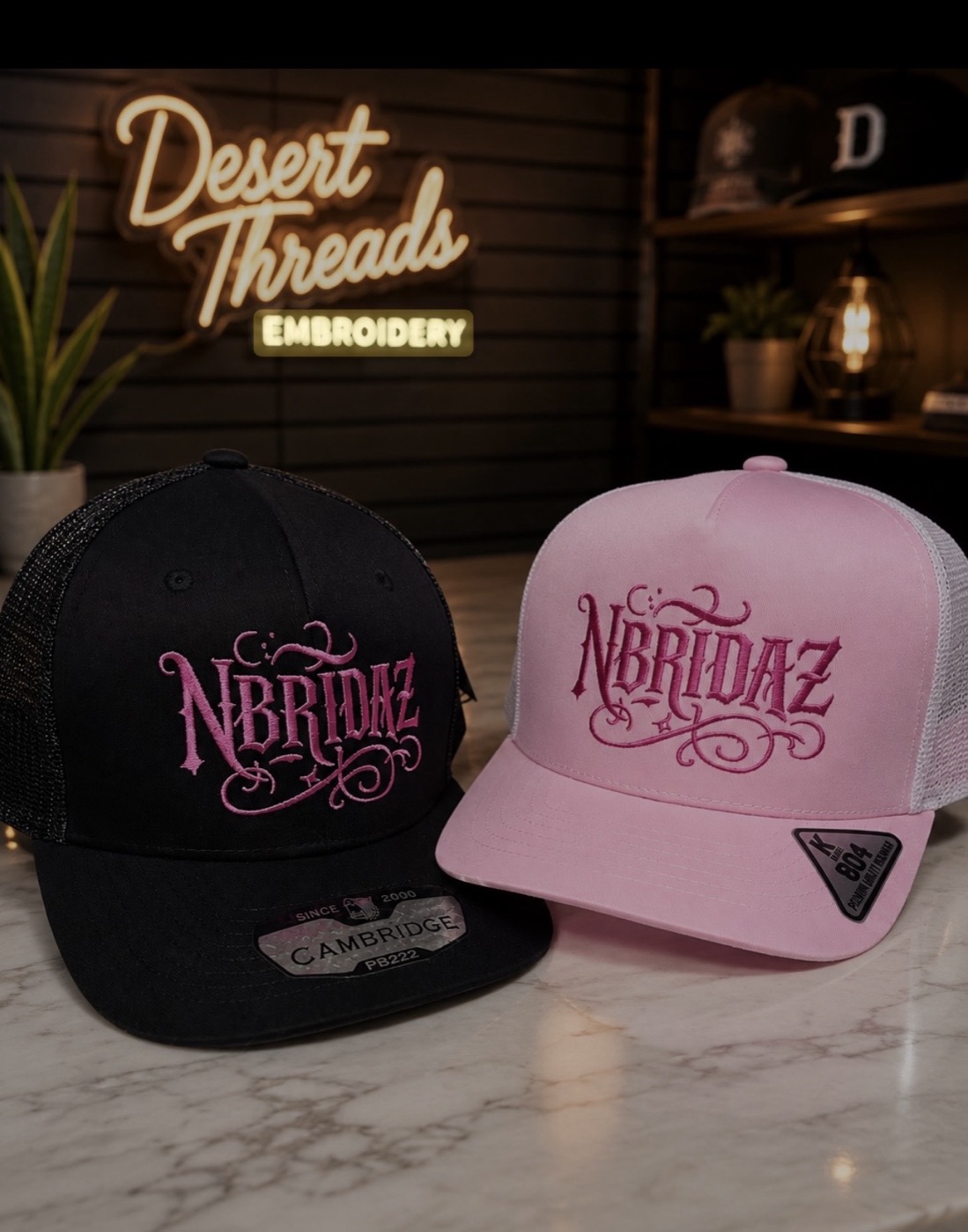 Black and pink NBridaz trucker caps with ornate lettering