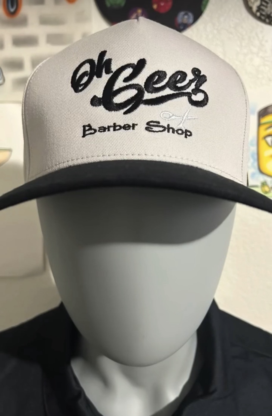 Trucker cap with the Oh Beer Barber Shop script logo and scissors icon